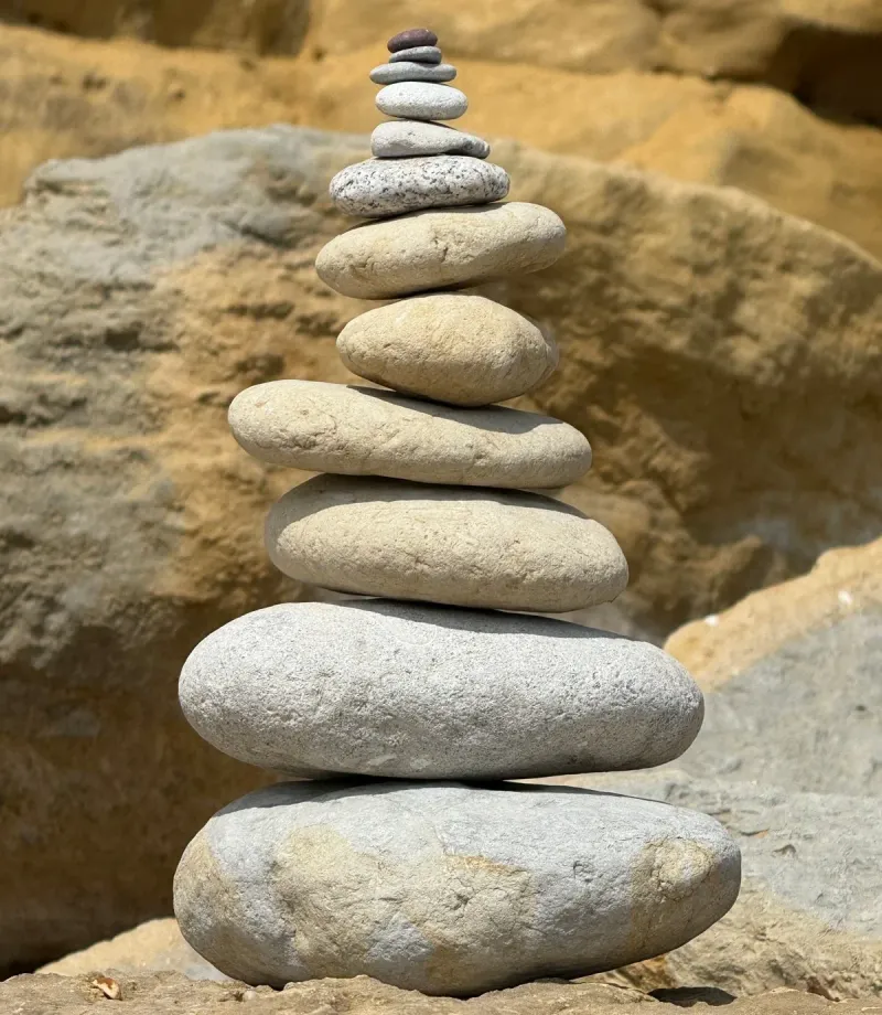 A balanced stack of smooth stones on a rock